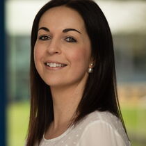 Portraitfoto Lena Gemmeker - sie hat schulterlanges braunes haar und trägt eine helle Bluse.