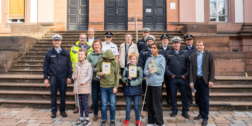 Gruppenbild der Polizeiaktion: Polizisten der Verkehrsinspektion und des Regionale Verkehrsdienst Marburg-Biedenkopf zusammen mit Schüler*innen, einer Lehrerin, dem Vorstand, Schulleiter und Stadträtin Kirsten Dinnebier.