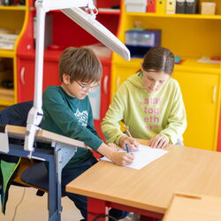 Zwei Schüler*innen arbeiten gemeinsam an einem Arbeitsblatt.