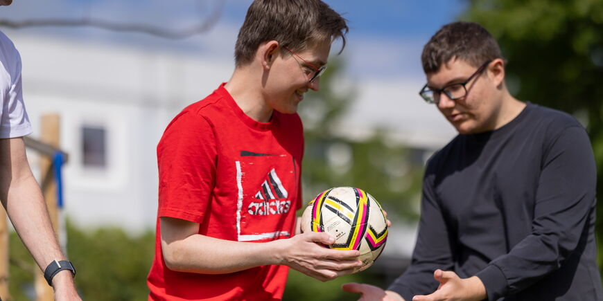 Auf dem blistaCampus reichen Teilnehmende der Bewegungsförderung sich einen Ball weiter.