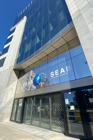 Man sieht ein hohes Glasgebäude auf dem „european external action service“ und „service européen pour l’action exté“ steht.