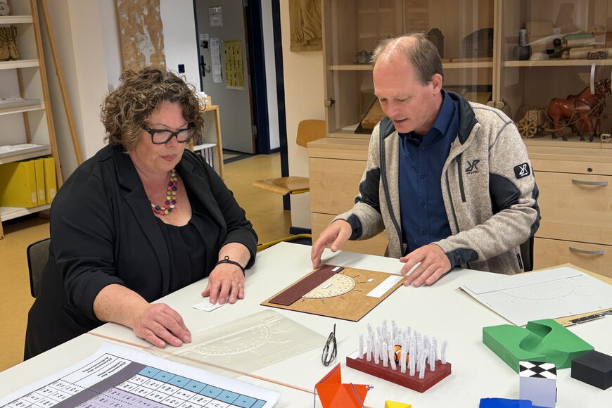 Susanne Simmler im Gespräch mit Dr. Mahnke, vor ihnen liegen Tastmodelle.