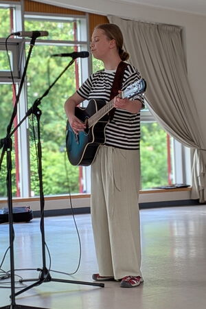 Enie sing und spielt Gitarre auf der Bühne.