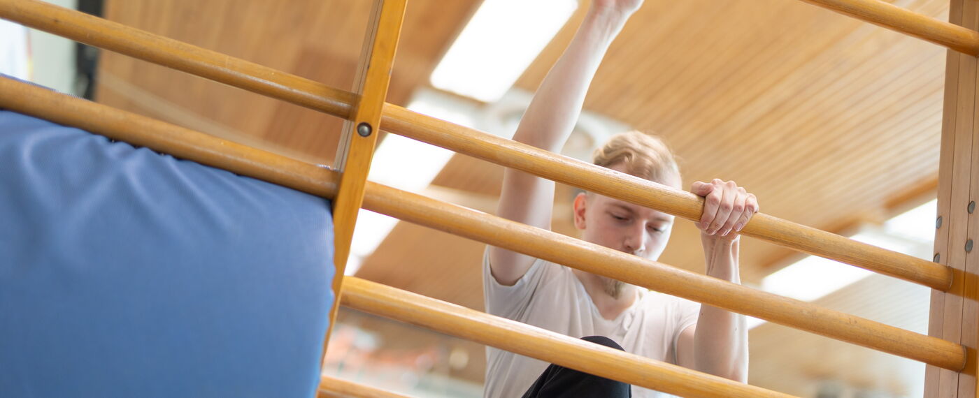 Ein Schüler erklimmt eine Sprossenwand