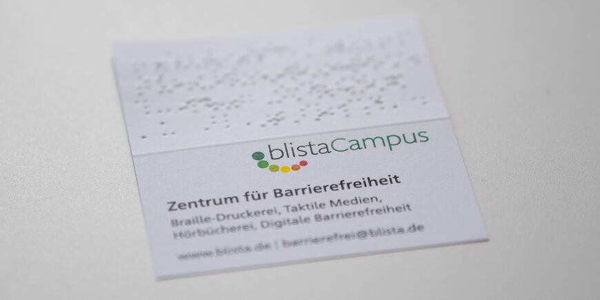 Eine Klapp-Visitenkarte mit Schwarz- und Punktschrift.