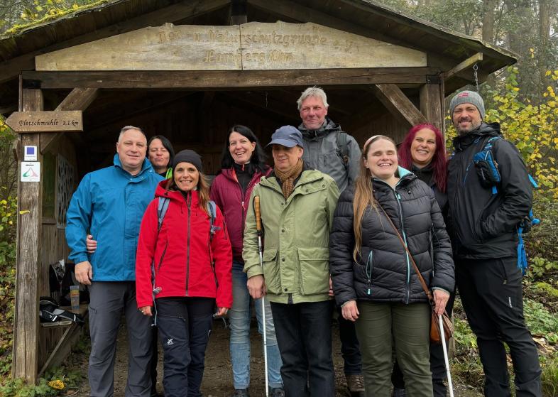 9 fröhliche blista-Wandersleut‘ bei einem kurzen Päuschen im Wald