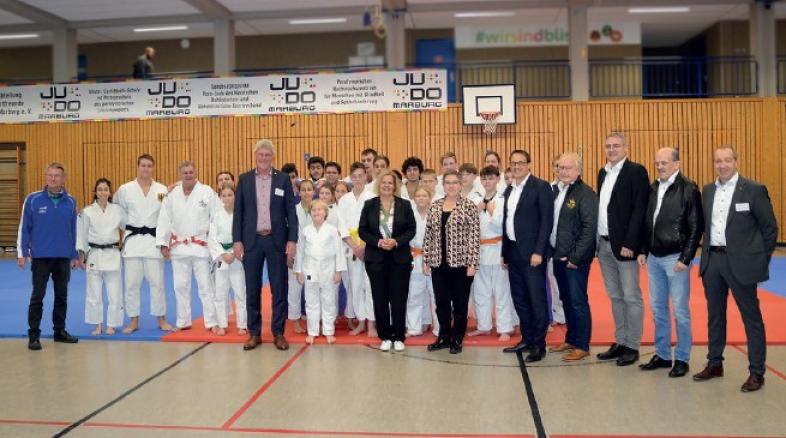 Gruppenbild mit Judoka in der Sporthalle. v.l.n.r.: Christian Rhode, Markus Zaumbrecher, Maarten Kubeja, Nancy Faeser, Kirsten Dinnebier, Sören Bartol, Heinz Wagner, Björn Backes, Dr. Michael Richter, Patrick Temmesfeld