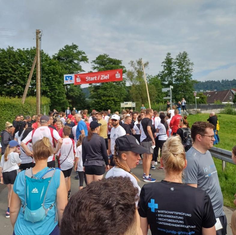 Eine Gruppe Läufer*innen steht unter einem Banner mit der Aufschrift „Start/Ziel“.